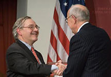 Alex Jones, director of the Shorenstein Center (right), greets E.J. Dionne, Jr., at the Forum.
