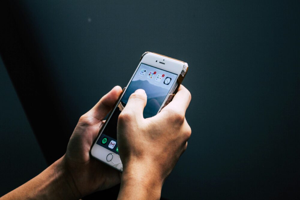 a person holding a smart phone in their hands. photo by Brandon https://unsplash.com/@bokv