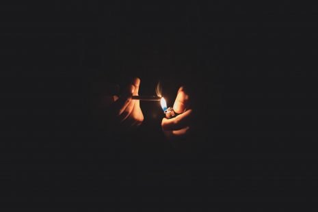 a person lights a cigarette in the dark