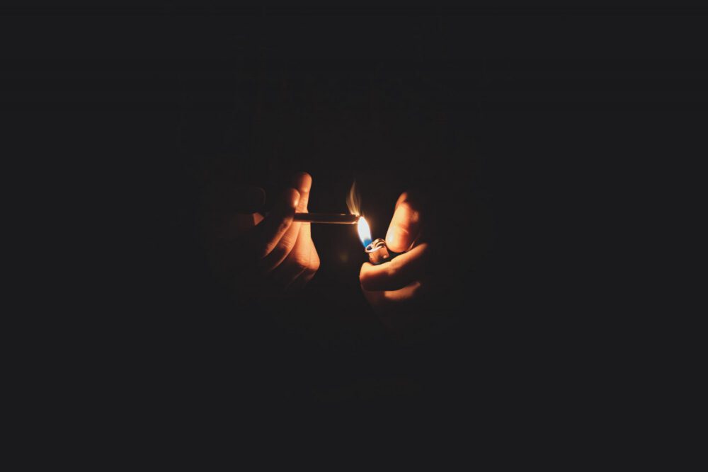 a person lights a cigarette in the dark