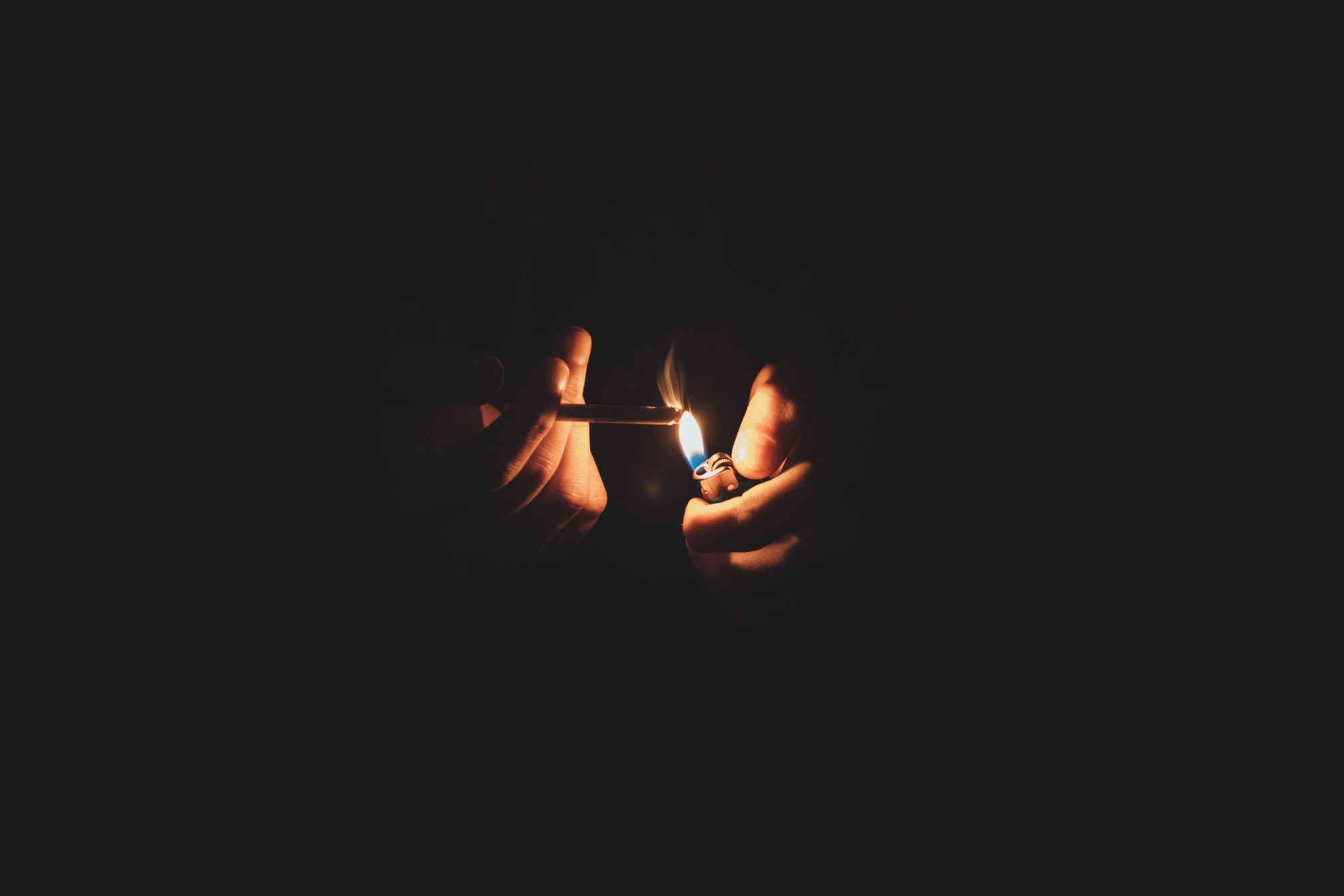 a person lights a cigarette in the dark