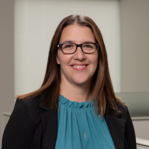 photo of Nicole Dillon, a light-skinned woman with brown hair, wearing a black blazer and blue shirt