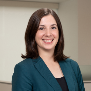 Photo of Caroline Kracunas, a light-skinned woman with shoulder-length brown hair, wearing a blazer.