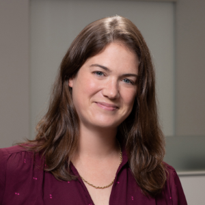 photo of Liz Schwartz, a light-skinned woman with sohulder-length brown hair, wearing a red shirt