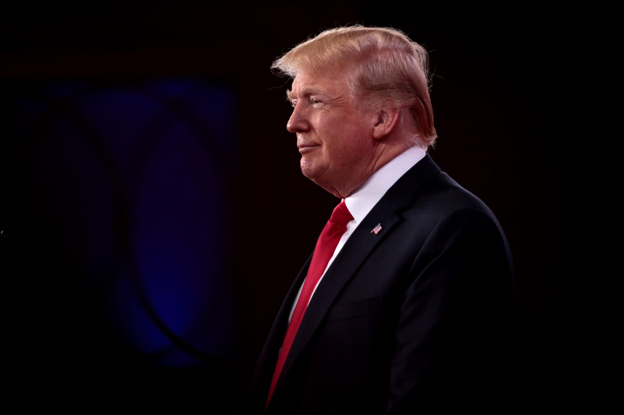 Photo of former president Donald Trump, in profile with a dark background