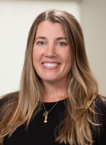 Photo of Lindsay Underwood, a light-skinned woman with long blonde hair, wearing a black shirt