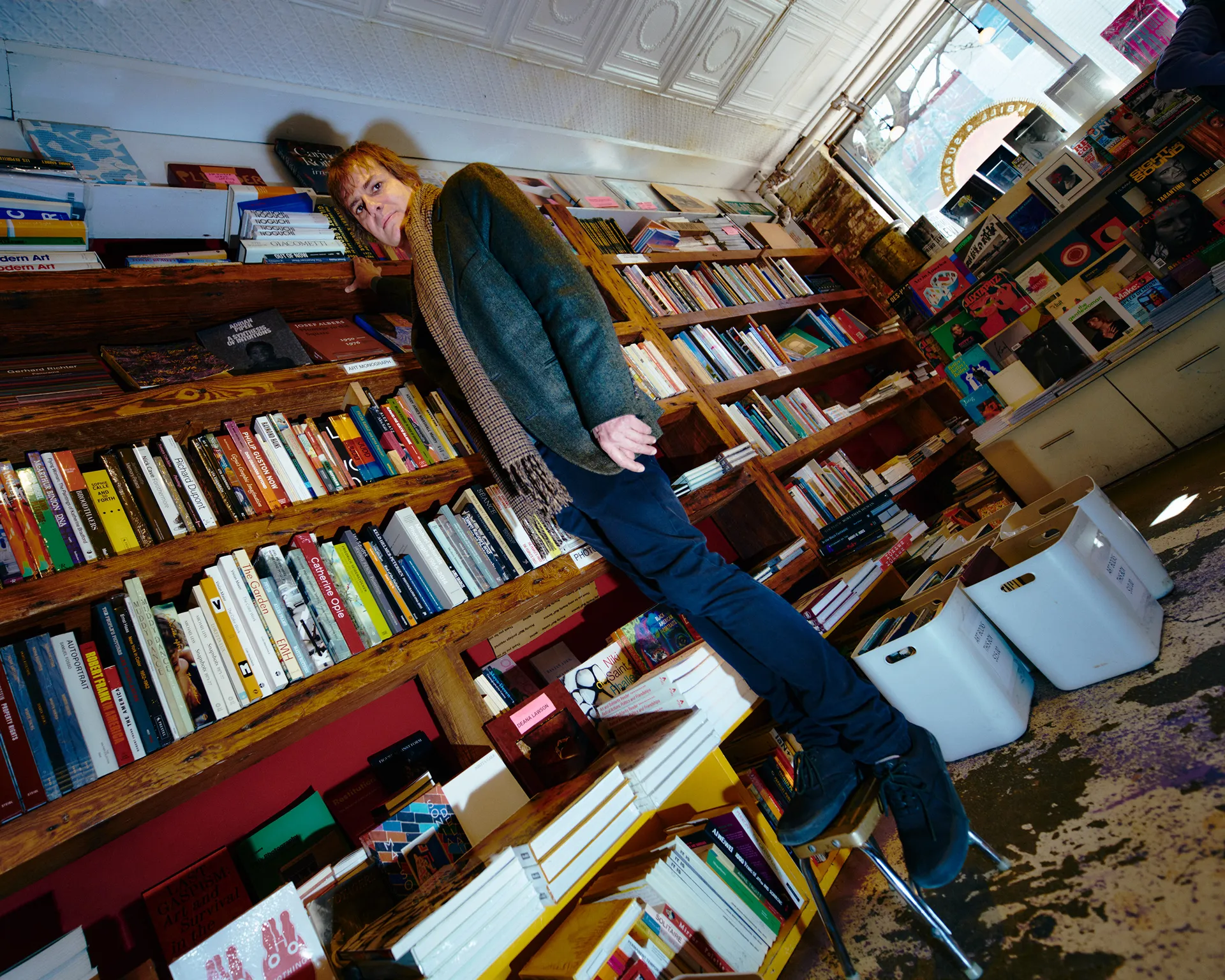 Photograph of a person in front of a full bookshelf