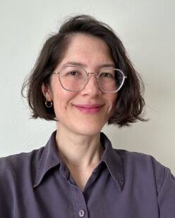 Sydney Tanigawa, a woman with light skin and chin length dark hair, wearing glasses and a collared shirt