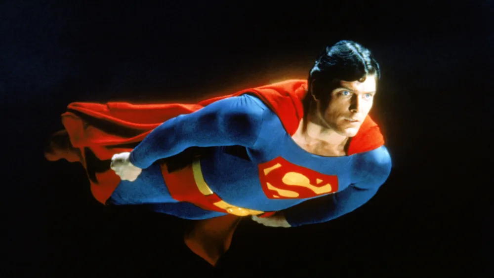 Image of person wearing a Superman costume and flying in the sky