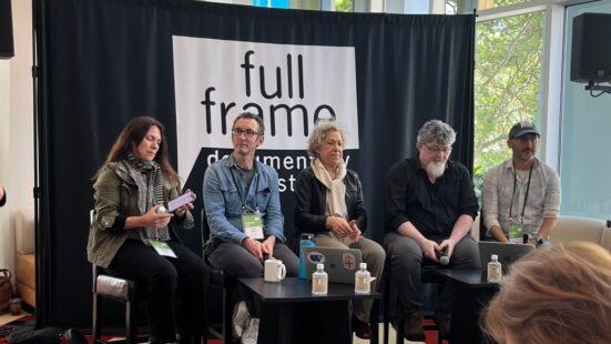 Photograph of five people sitting in front of a Full Frame Documentary Film Festival sign
