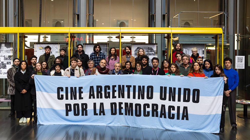 Photograph of people holding a sign that says "Cine Argentino Unido por la democracia"