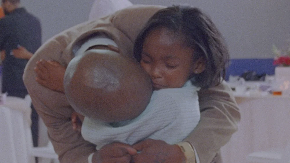 Photograph of an adult and a child hugging