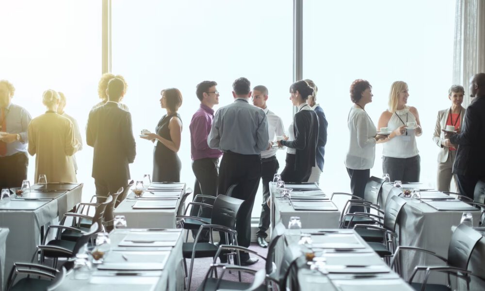 Photograph of people standing in a room talking with one another