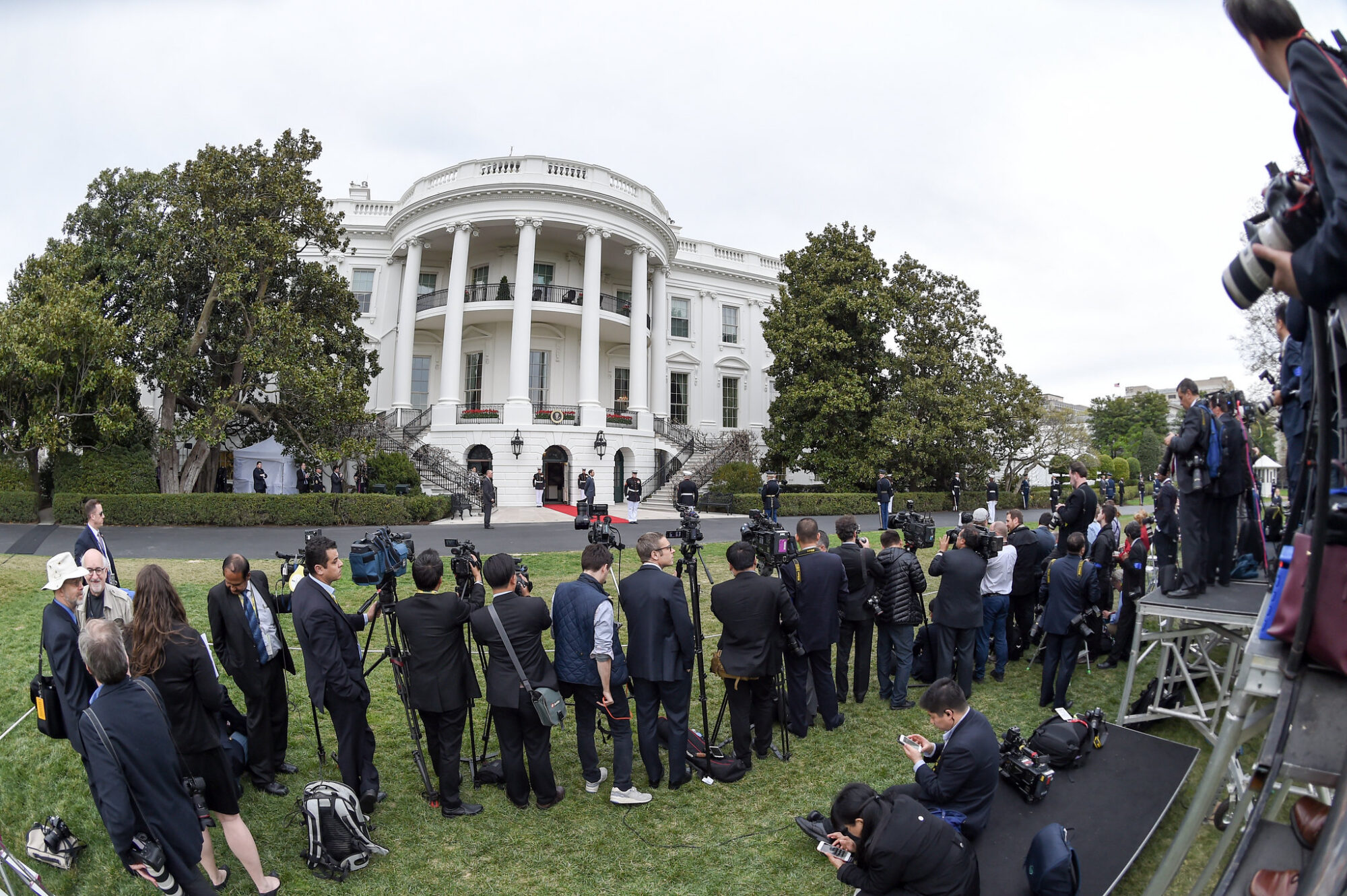 reporters line up outside of the White House with cameras. Photo by Ben Solomon/U.S. Department of State. In the public domain via Creative Commons https://www.flickr.com/photos/127744844@N06/25568250763
