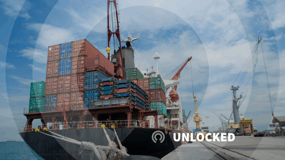 stacks of shipping containers on a boat docked in a port