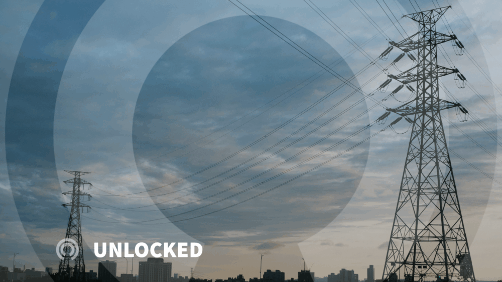 image of a transmission tower at dusk with the city skyline in the background. The 