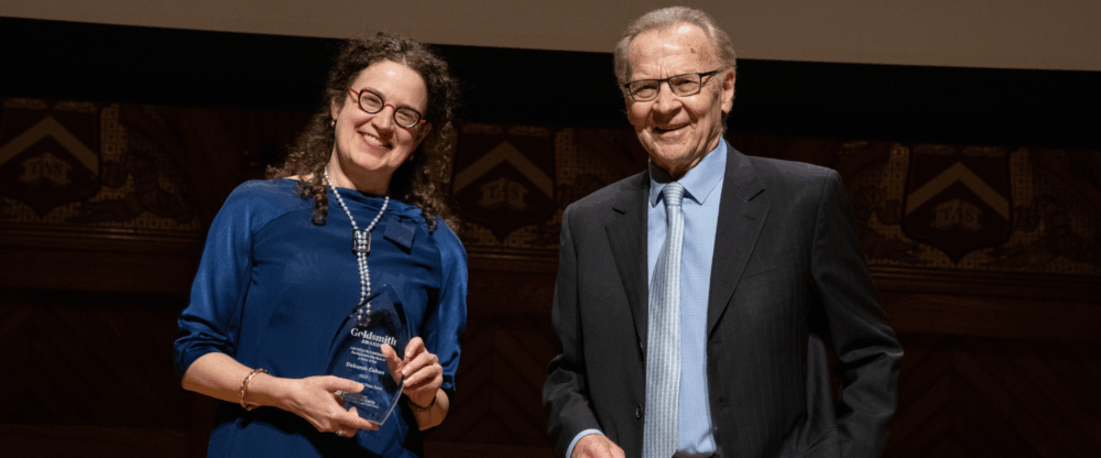Goldsmith Book Prize Winner Deborah Cohen stands on stage with Professor Thomas Patterson.